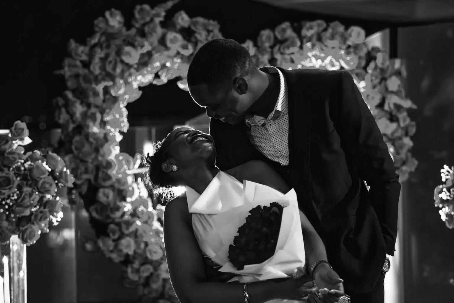 Afifoluwa and Mihlali embracing in front of a floral arch