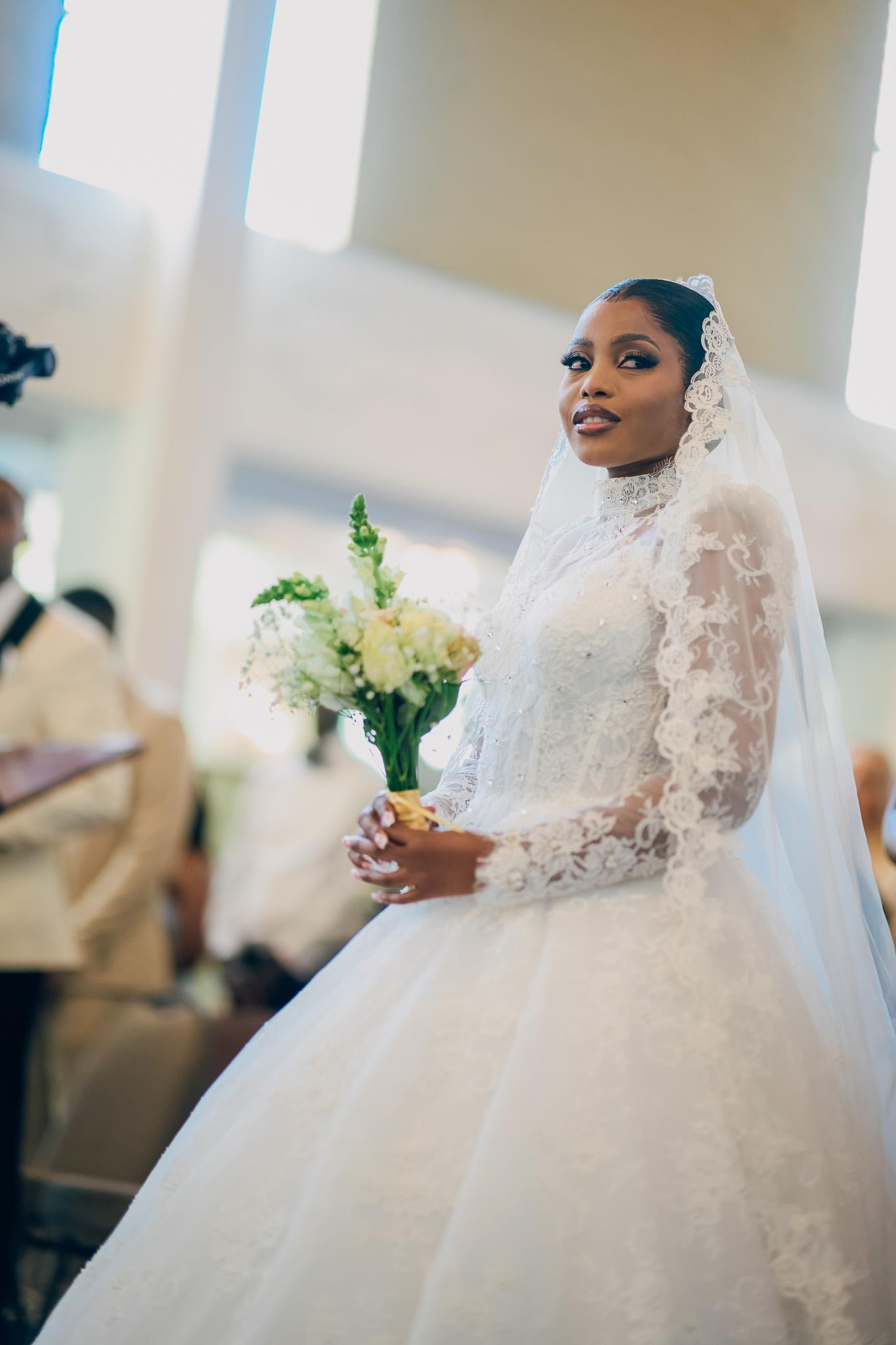Bride holding her bouquet and looking towards the front of the church.