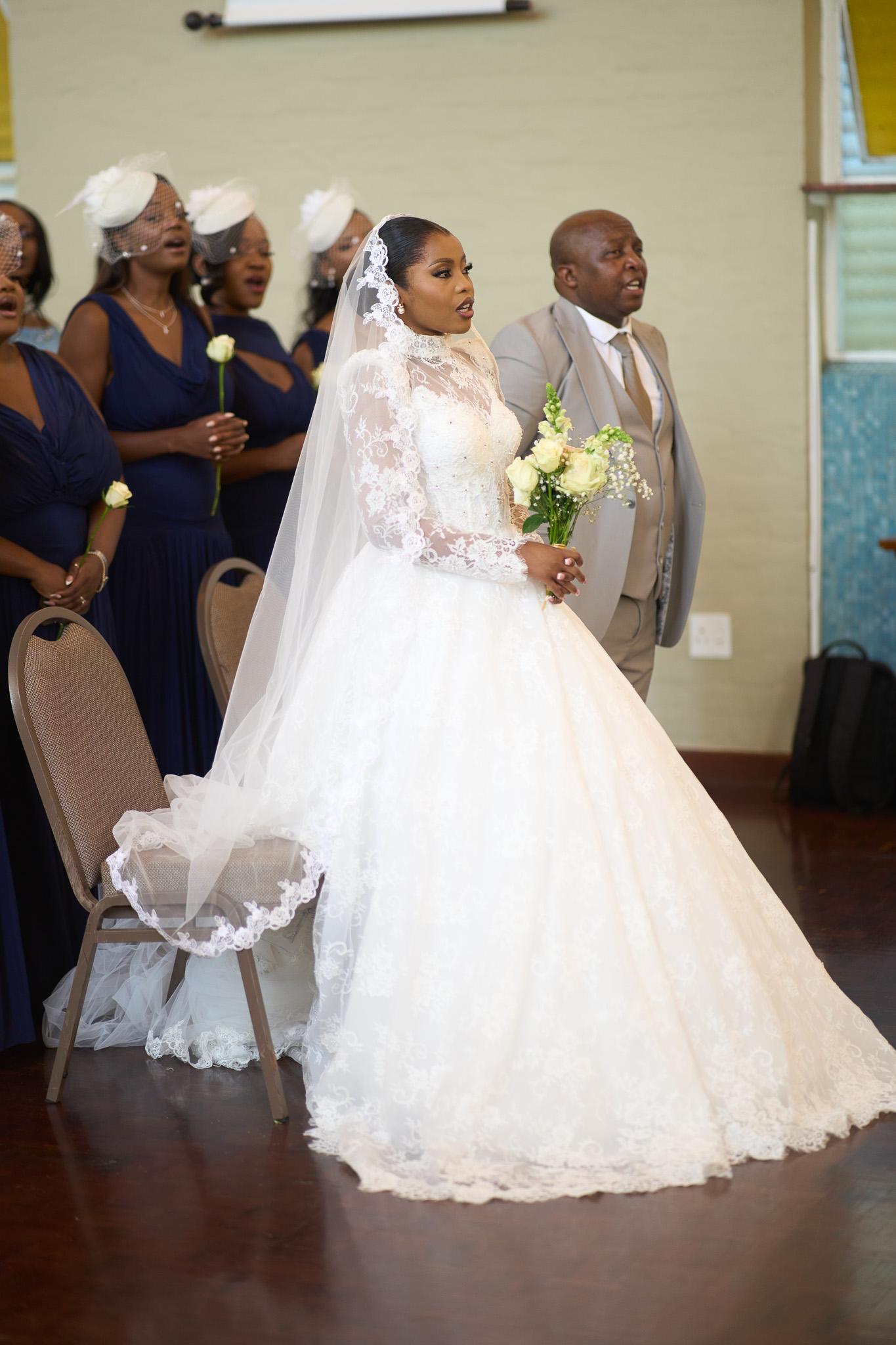 Bride standing with guests in the church pews.
