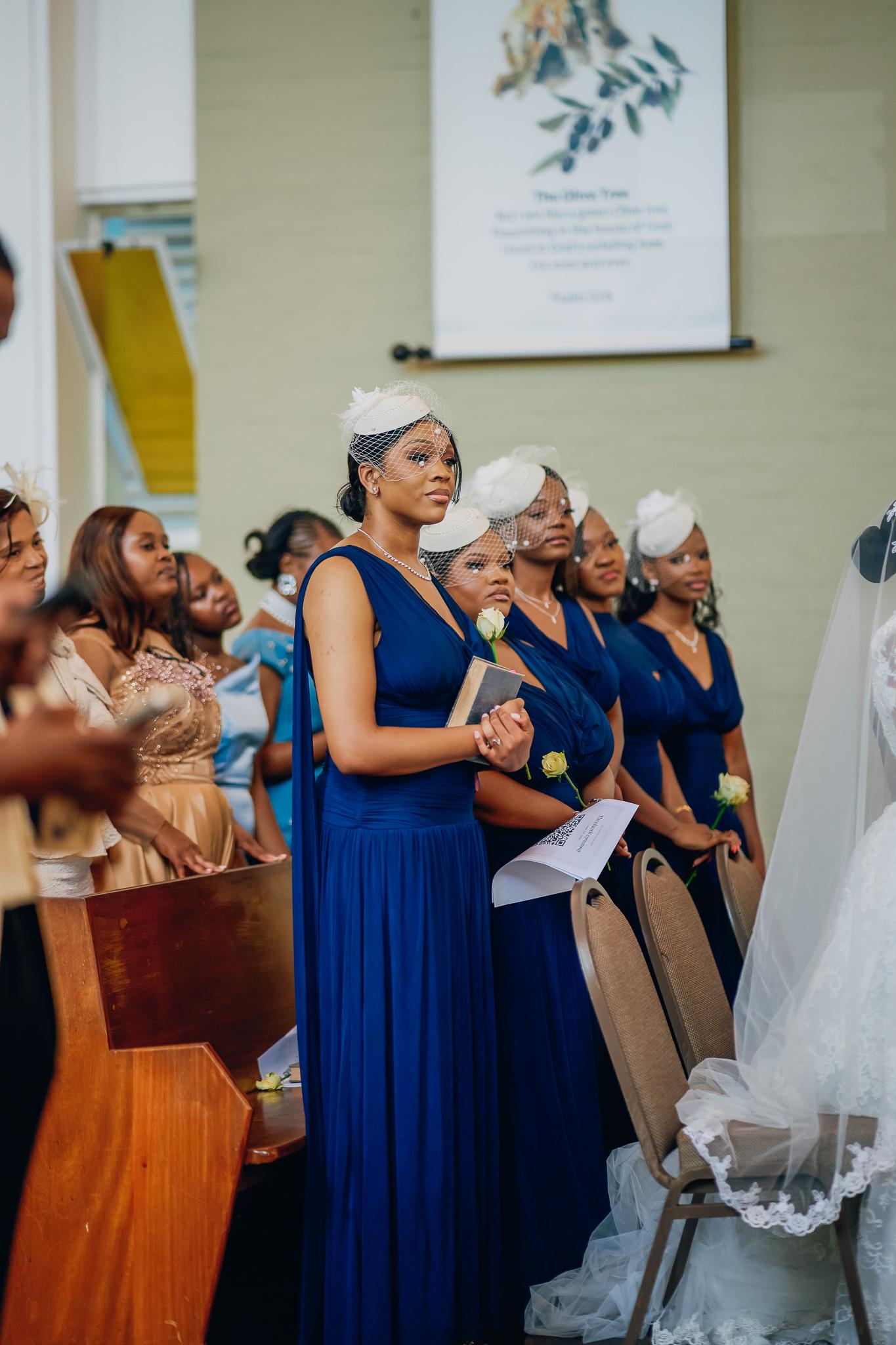 Guests in navy dresses standing together during the service.