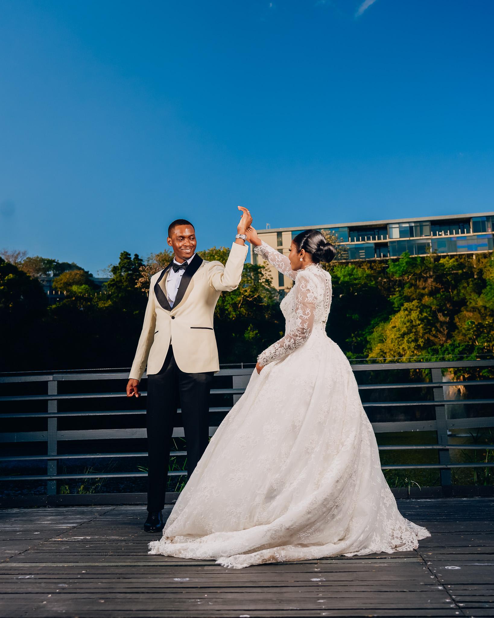 Bride turning beneath the groom’s raised hand on the terrace.