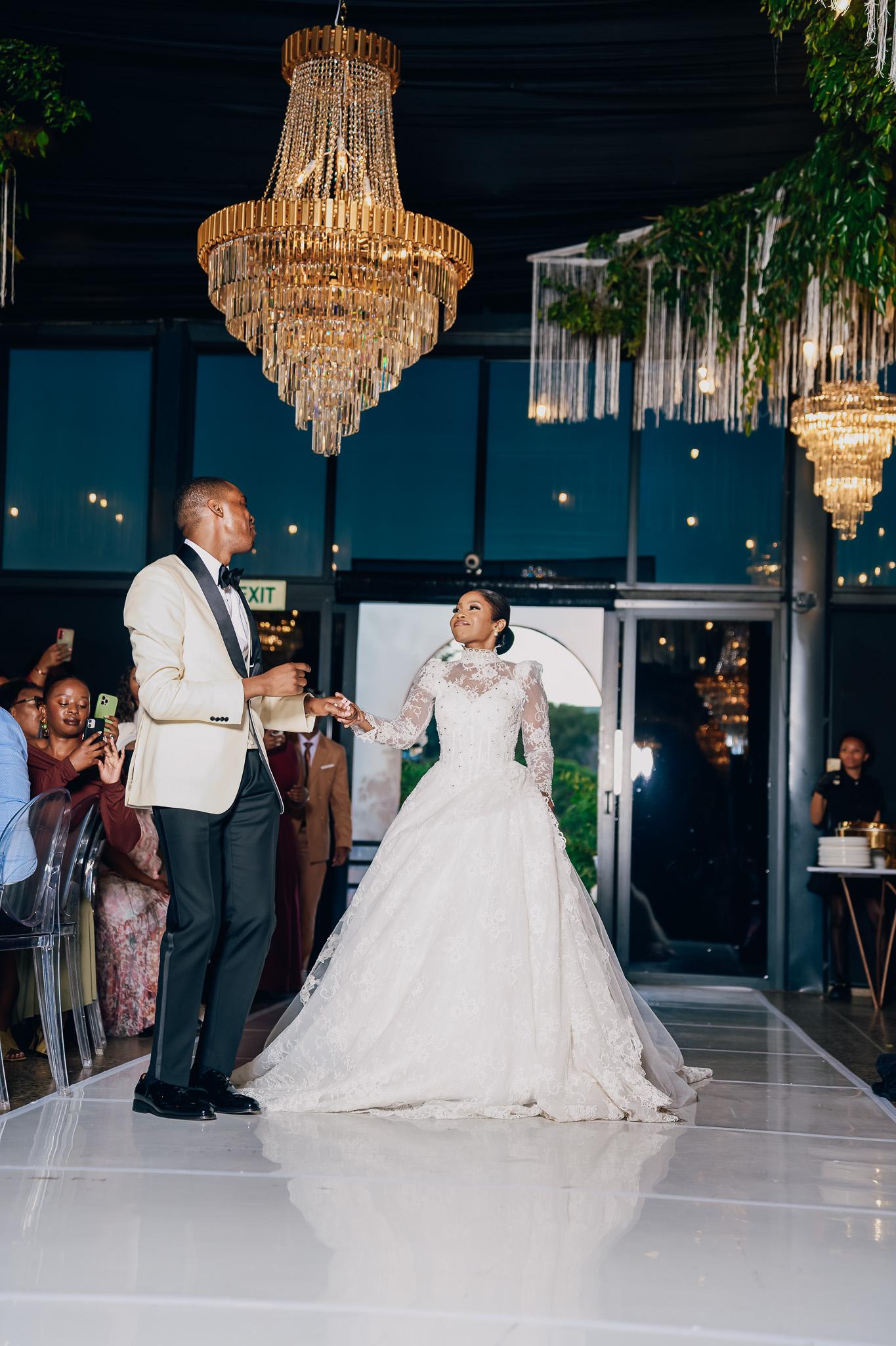 Bride and groom dancing hand in hand at their reception.